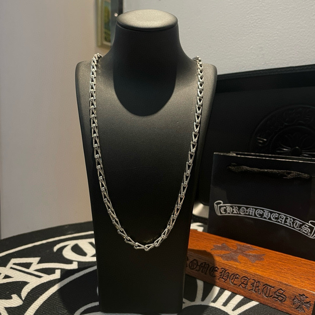 Silver-tone chain necklace on black display bust with layered links