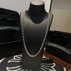 Silver-tone chain necklace shown on a black display bust, front view