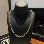 Silver-tone chain necklace with repeating link pattern on black bust display