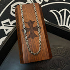 Silver-tone chain necklace draped over a brown wooden presentation stand