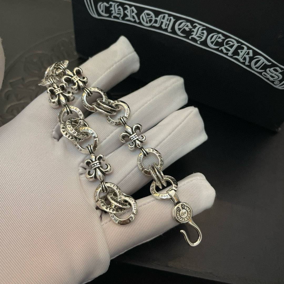 Silver-tone charm bracelet with lobster clasp and fleur-de-lis charm details