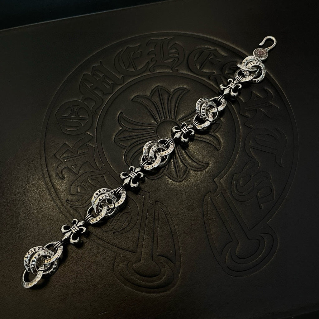 Silver-tone charm bracelet with central flower charm and linked medallions