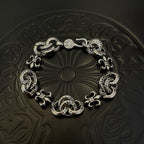 Silver-tone charm bracelet with oval links and decorative fleur-de-lis motifs