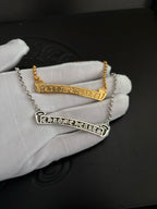 Gold- and silver-tone bar pendant necklaces held on a white glove