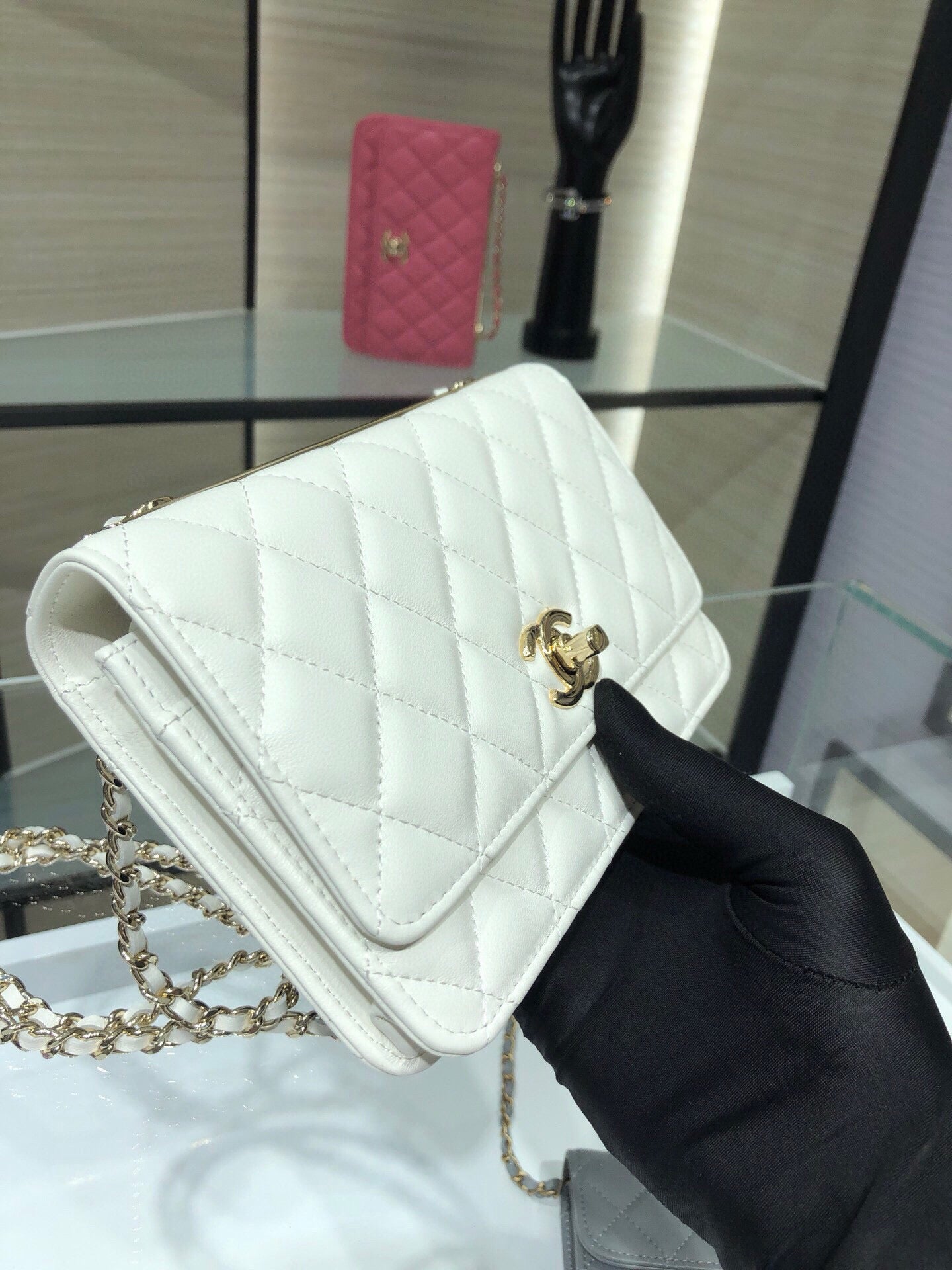 White quilted flap bag with gold logo turn-lock, chain strap, and leather shoulder strap