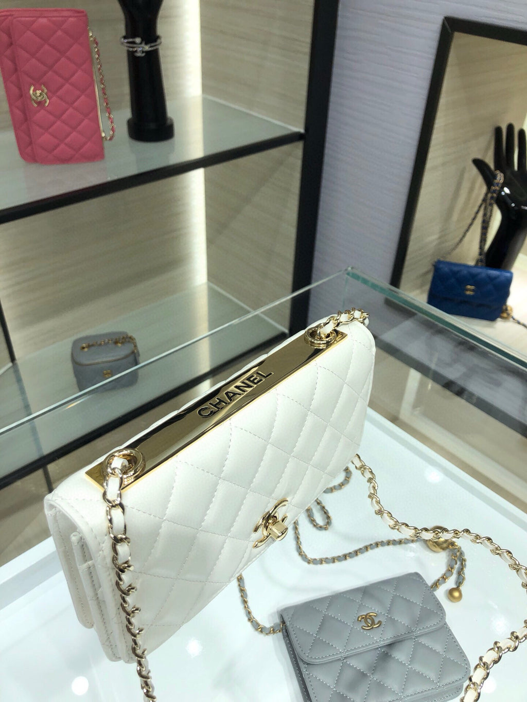 White quilted flap shoulder bag with gold chain strap and front turn-lock logo