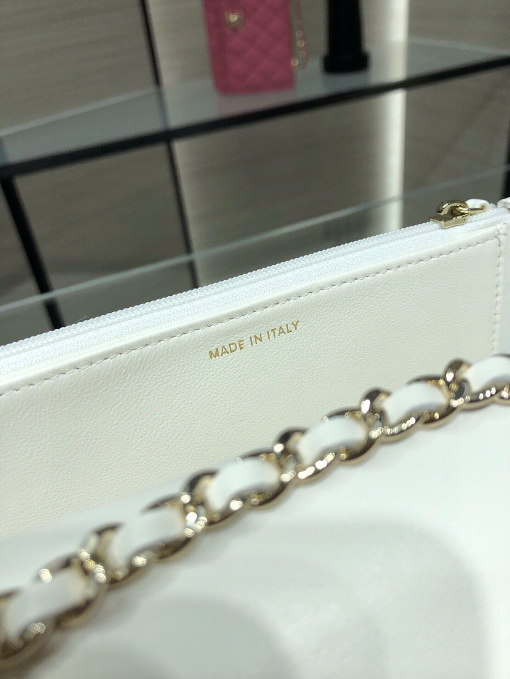 White leather bag detail showing 'MADE IN ITALY' stamp and gold chain link