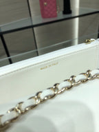 White leather bag detail showing 'MADE IN ITALY' stamp and gold chain link