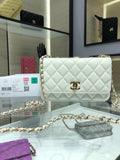 White quilted flap bag with gold chain strap and round logo turn-lock clasp