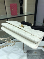 White quilted flap bag with gold logo turn-lock and chain strap, side view