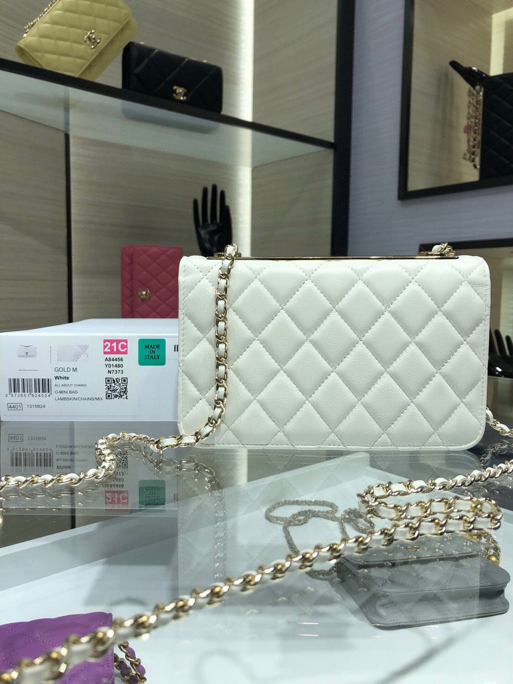 White quilted shoulder bag with gold chain strap and flap front logo turn-lock