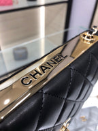 Gold CHANEL logo plate on a black quilted bag strap