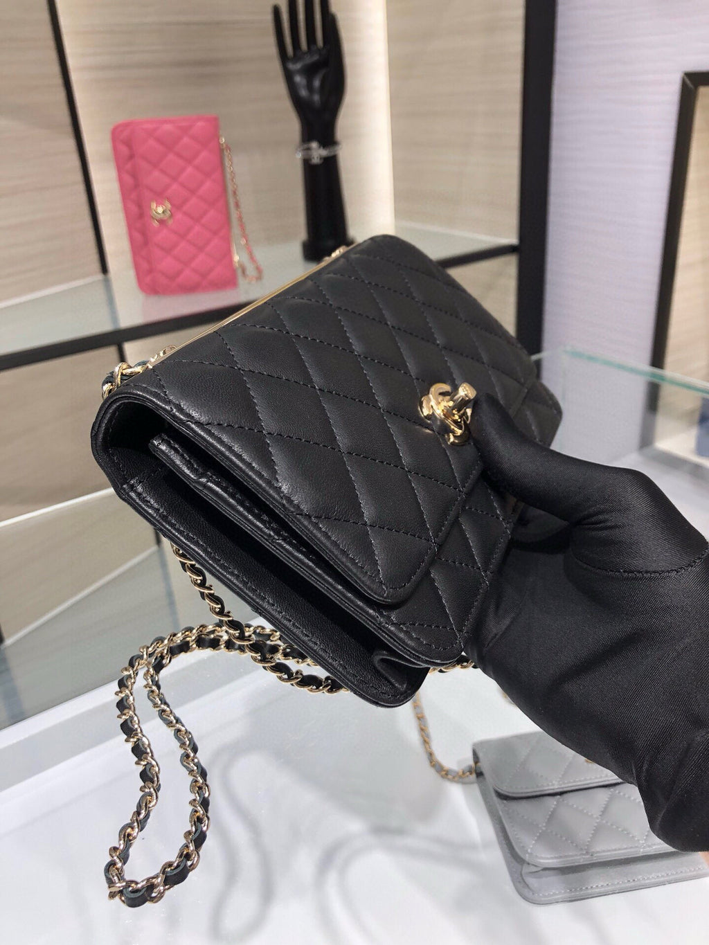 Black quilted flap shoulder bag with chain strap and small gold emblem