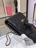 Black quilted flap shoulder bag with chain strap and small gold emblem