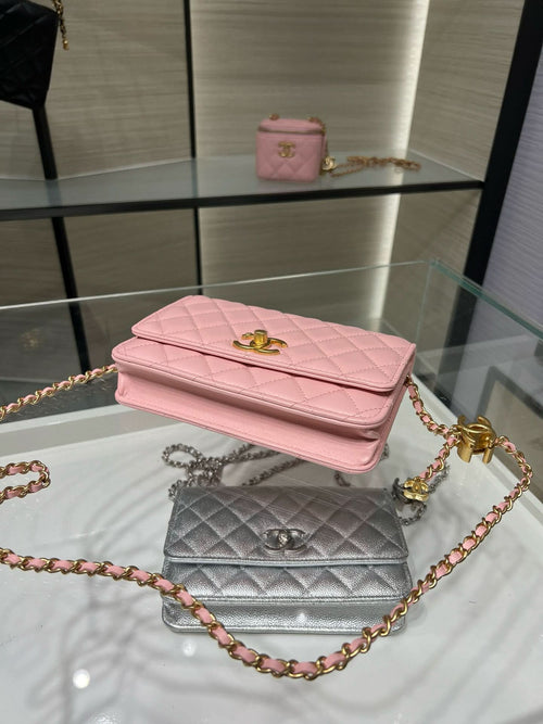 Pink quilted Chanel flap bag stacked with silver bag, both with gold chains