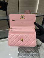 Pink quilted Chanel wallet-style bag with gold CC logo and chain strap
