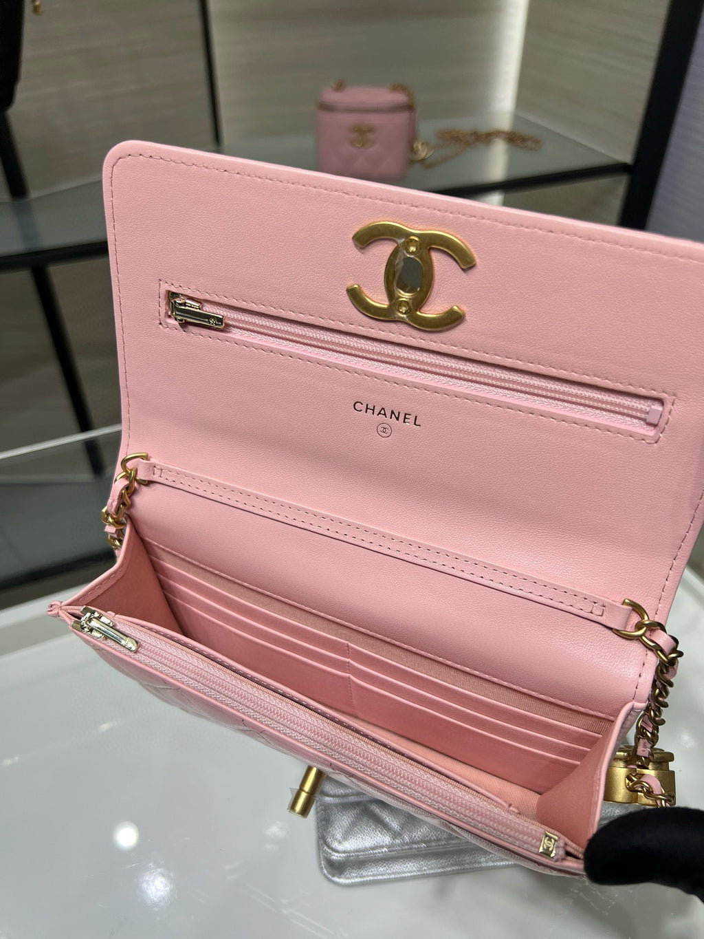 Open pink quilted Chanel bag with gold CC logo, top zip and chain strap