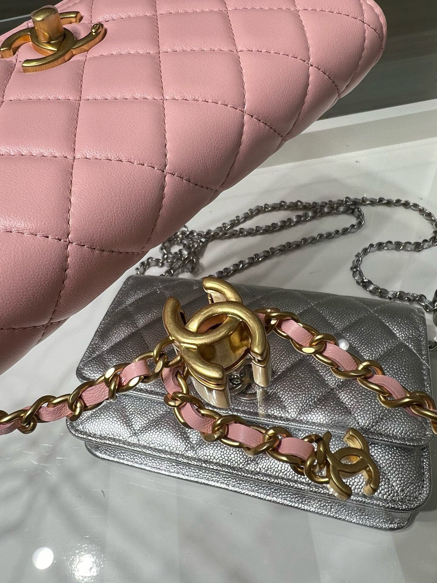 Close-up of silver quilted Chanel bag with gold chain strap and CC clasp