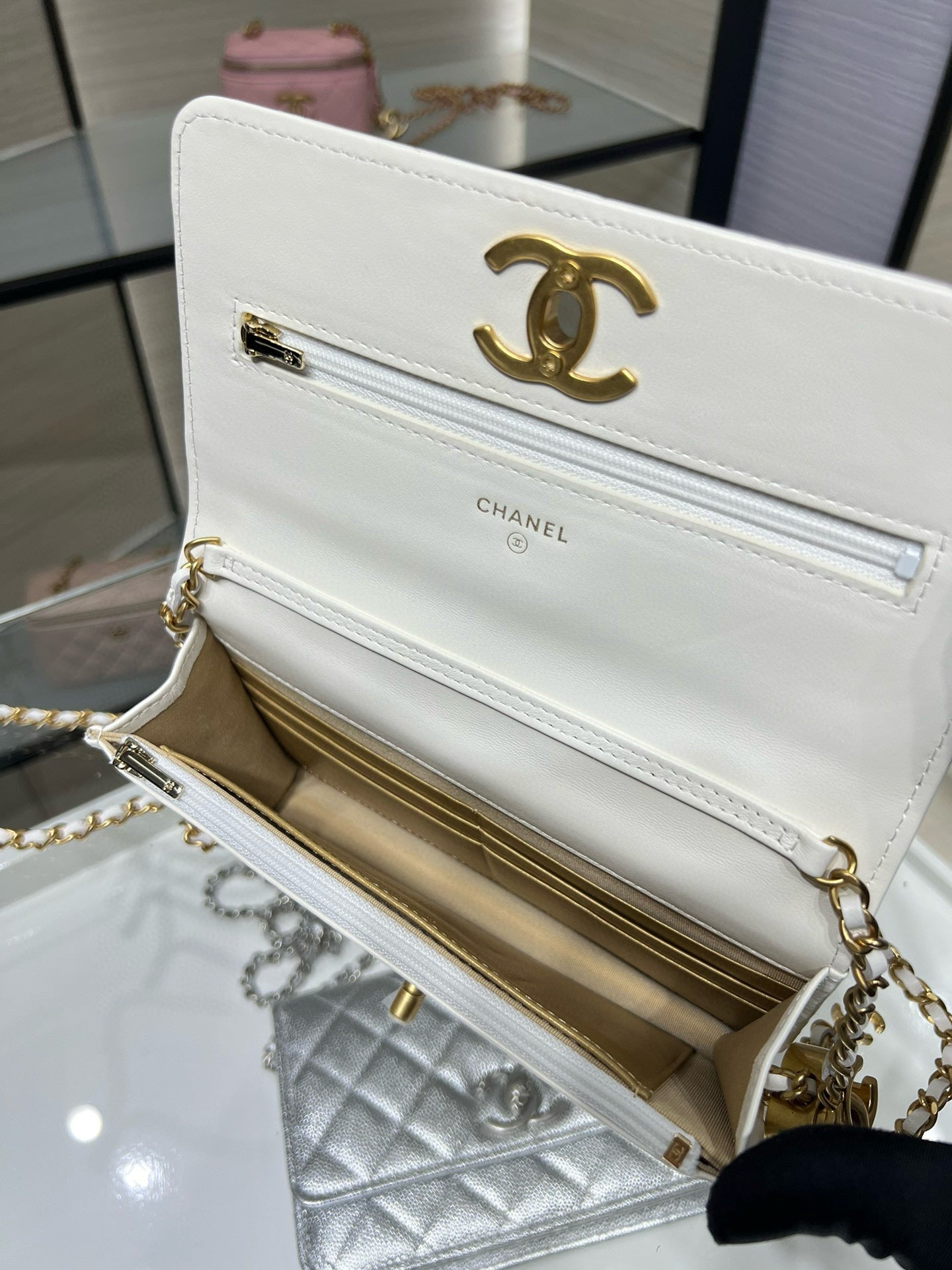 White Chanel quilted bag open view, showing gold CC hardware and chain strap