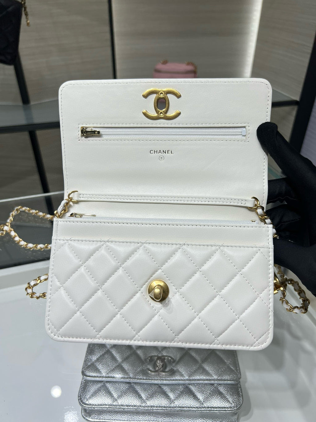 White Chanel quilted mini bag with gold CC logo, front clasp, and chain strap
