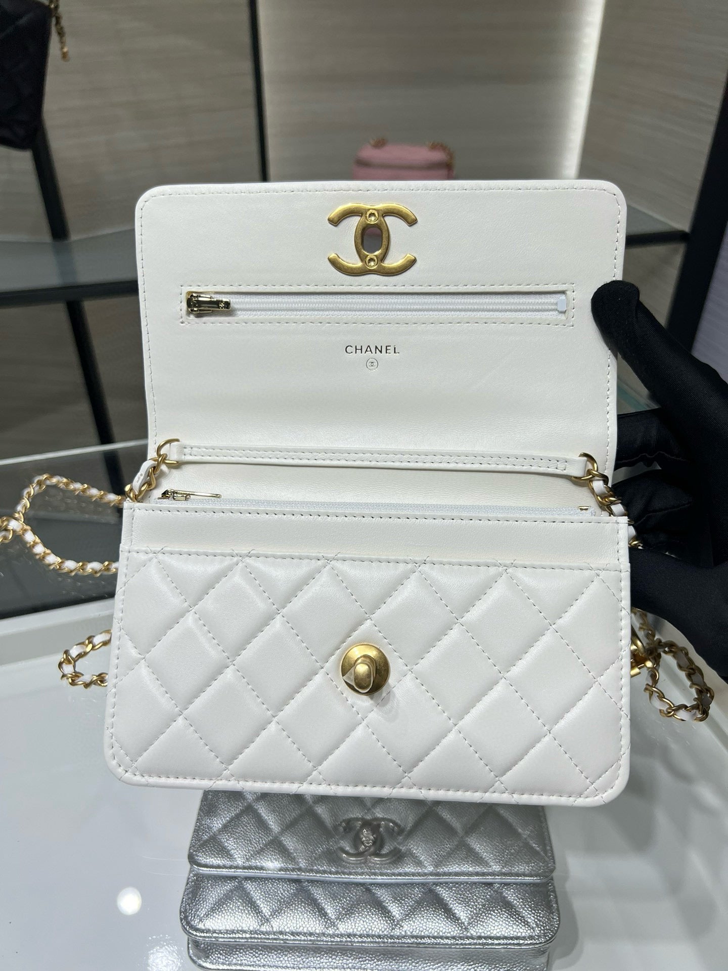 White quilted leather crossbody bag with gold Chanel logo, front panel and chain strap.