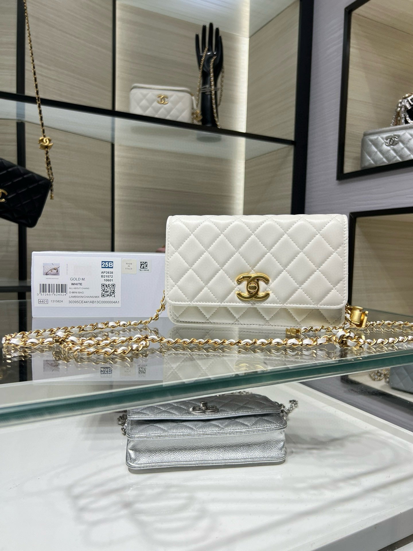 White quilted leather flap shoulder bag with gold Chanel logo and chain strap.