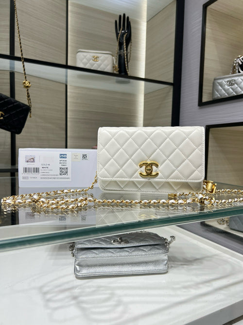 White quilted leather flap shoulder bag with gold Chanel logo and chain strap.