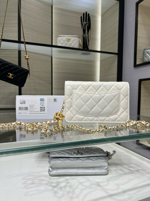 White quilted leather flap shoulder bag, gold hardware and chain strap, front view.