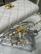 White quilted leather shoulder bag with gold chain strap and Chanel logo clasp, angled.