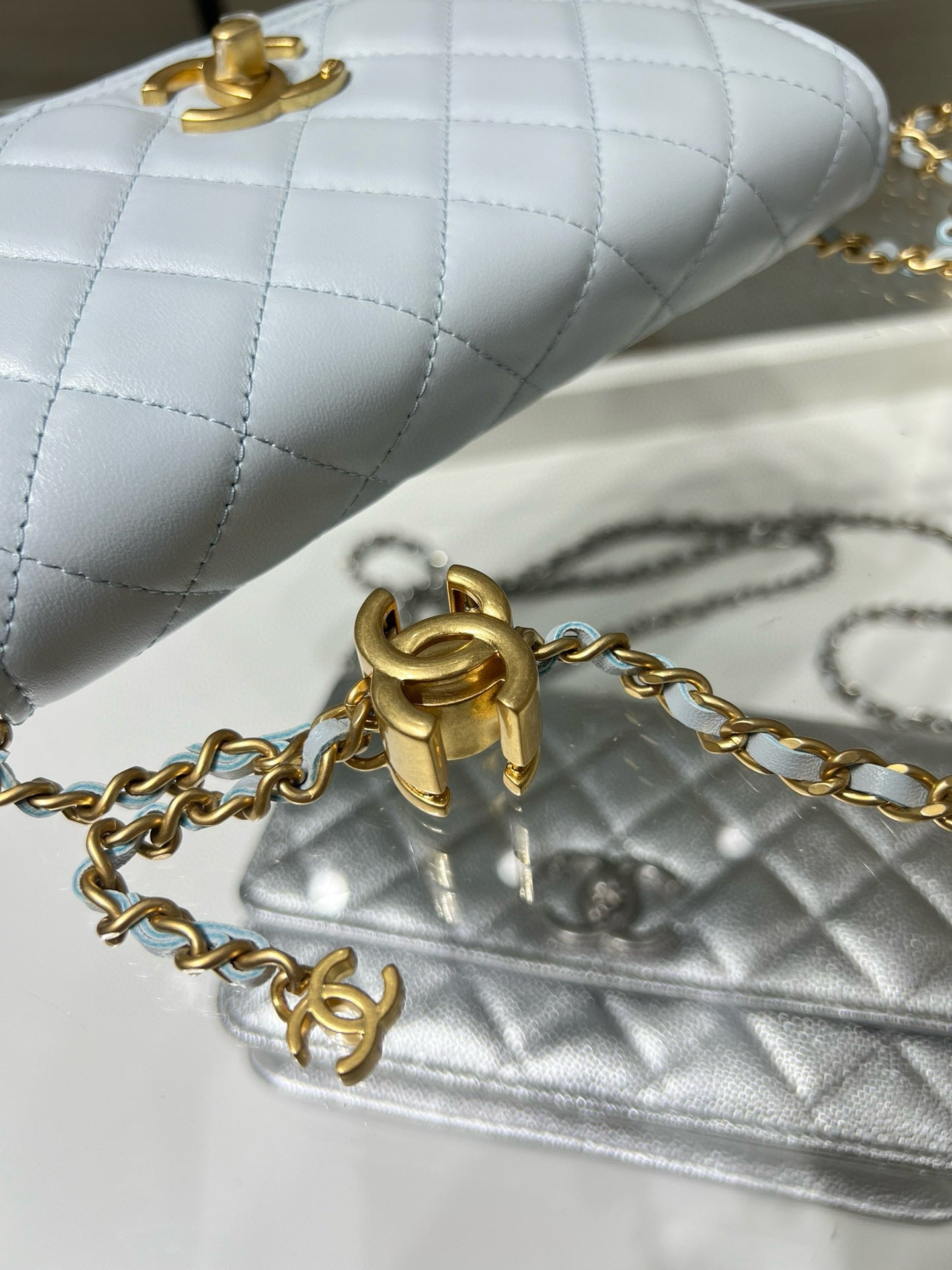 Chanel pale quilted shoulder bag with gold chain clasp close-up