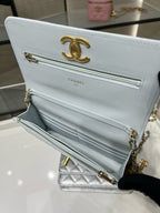 Chanel white quilted flap shoulder bag open, showing interior compartments and gold trim