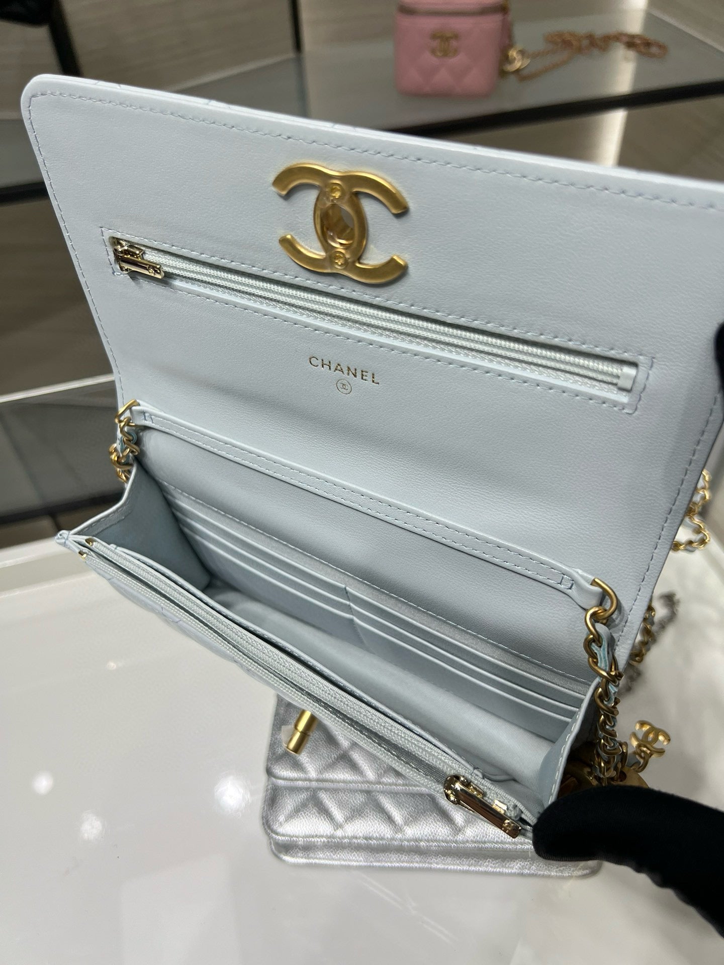 Chanel white quilted flap shoulder bag open, showing interior compartments and gold trim