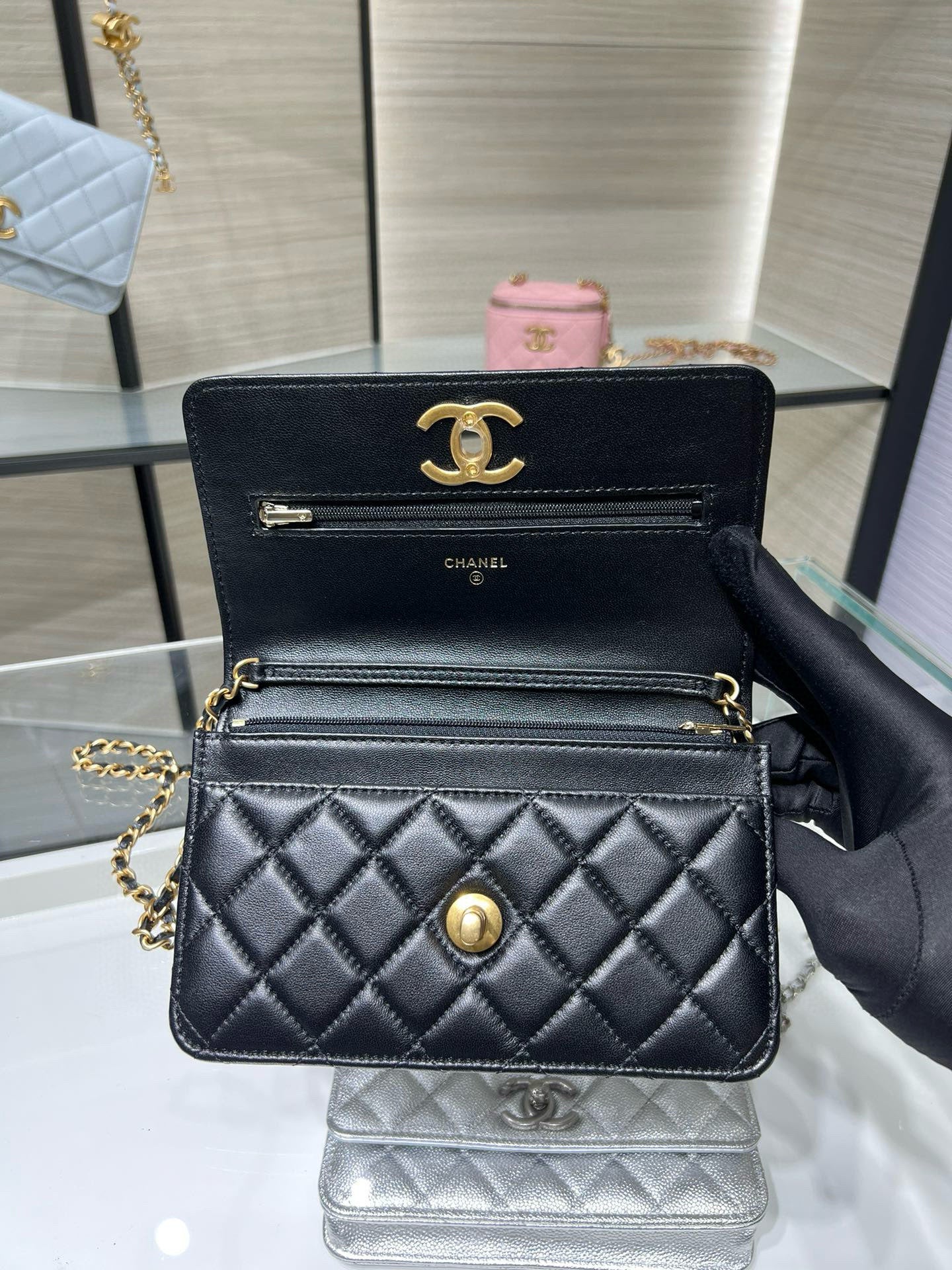 Dark quilted Chanel bag with front flap, chain strap, and gold hardware