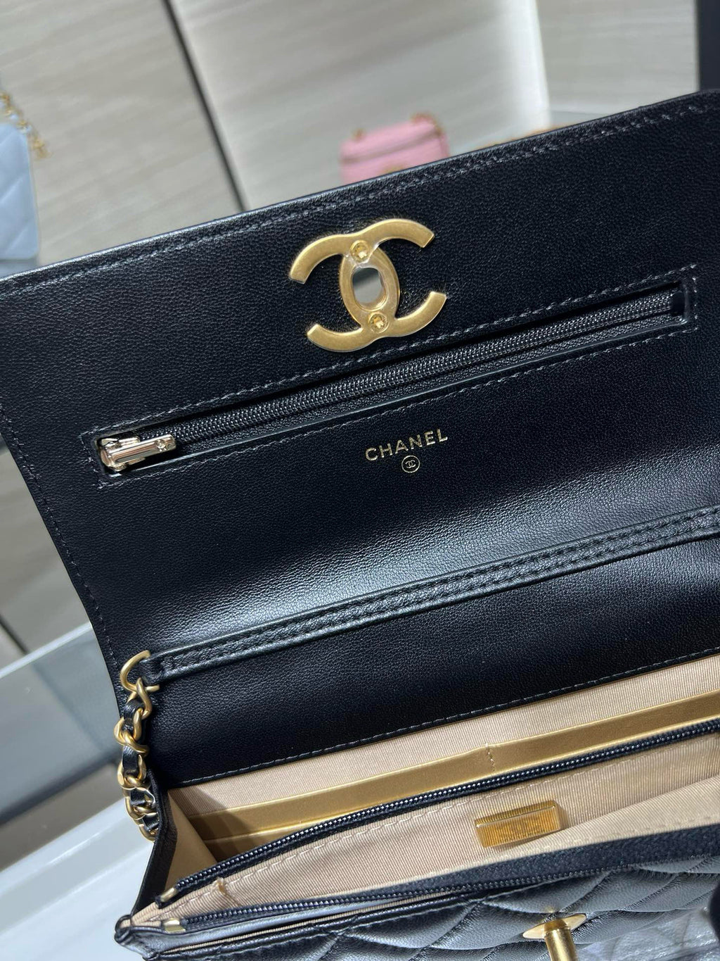 Dark Chanel bag with open flap, gold-tone CC logo, and chain strap