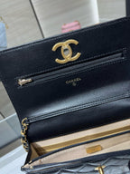 Dark Chanel bag with open flap, gold-tone CC logo, and chain strap