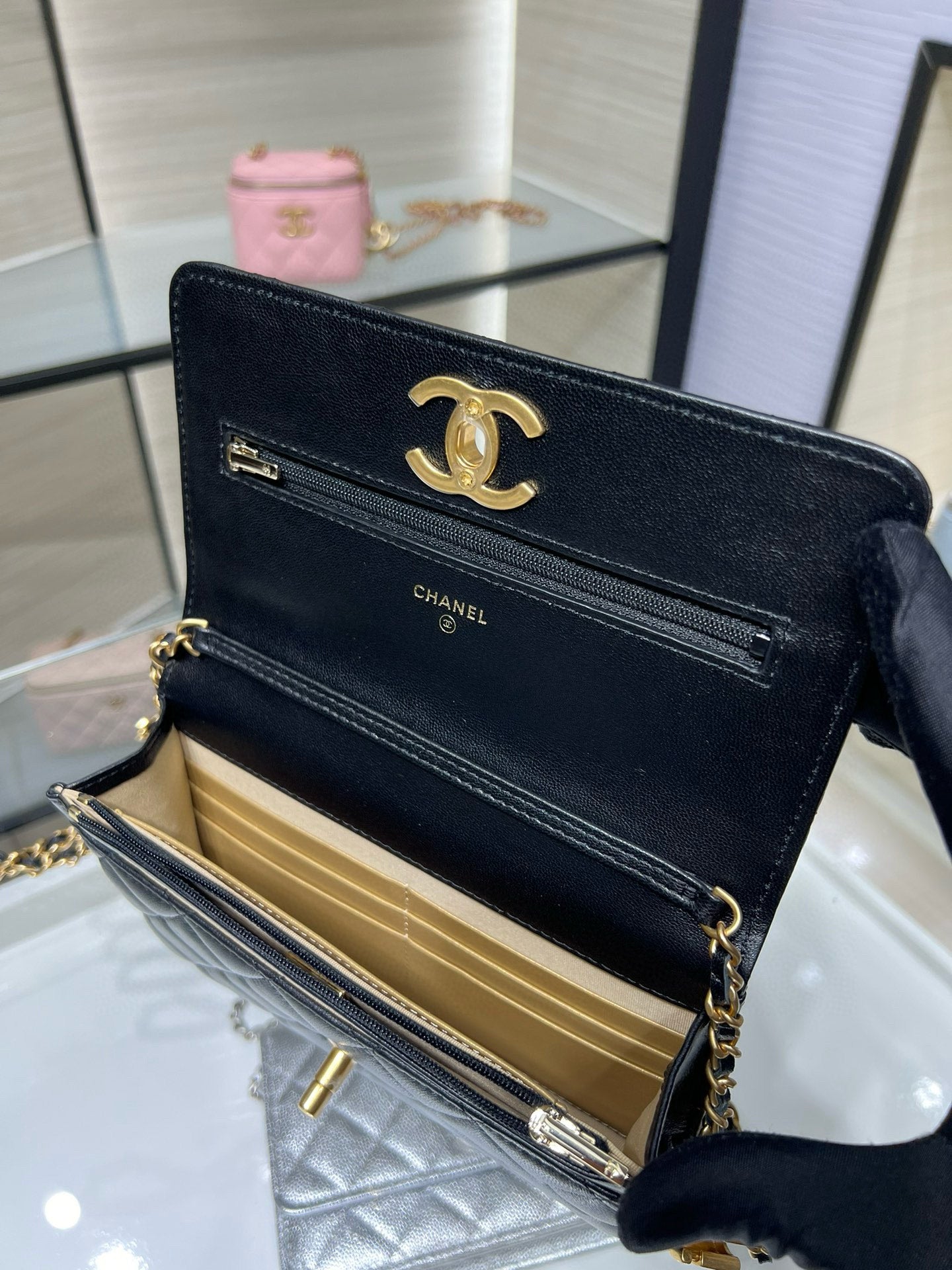 Dark Chanel bag open showing interior pocket and gold-tone chain strap