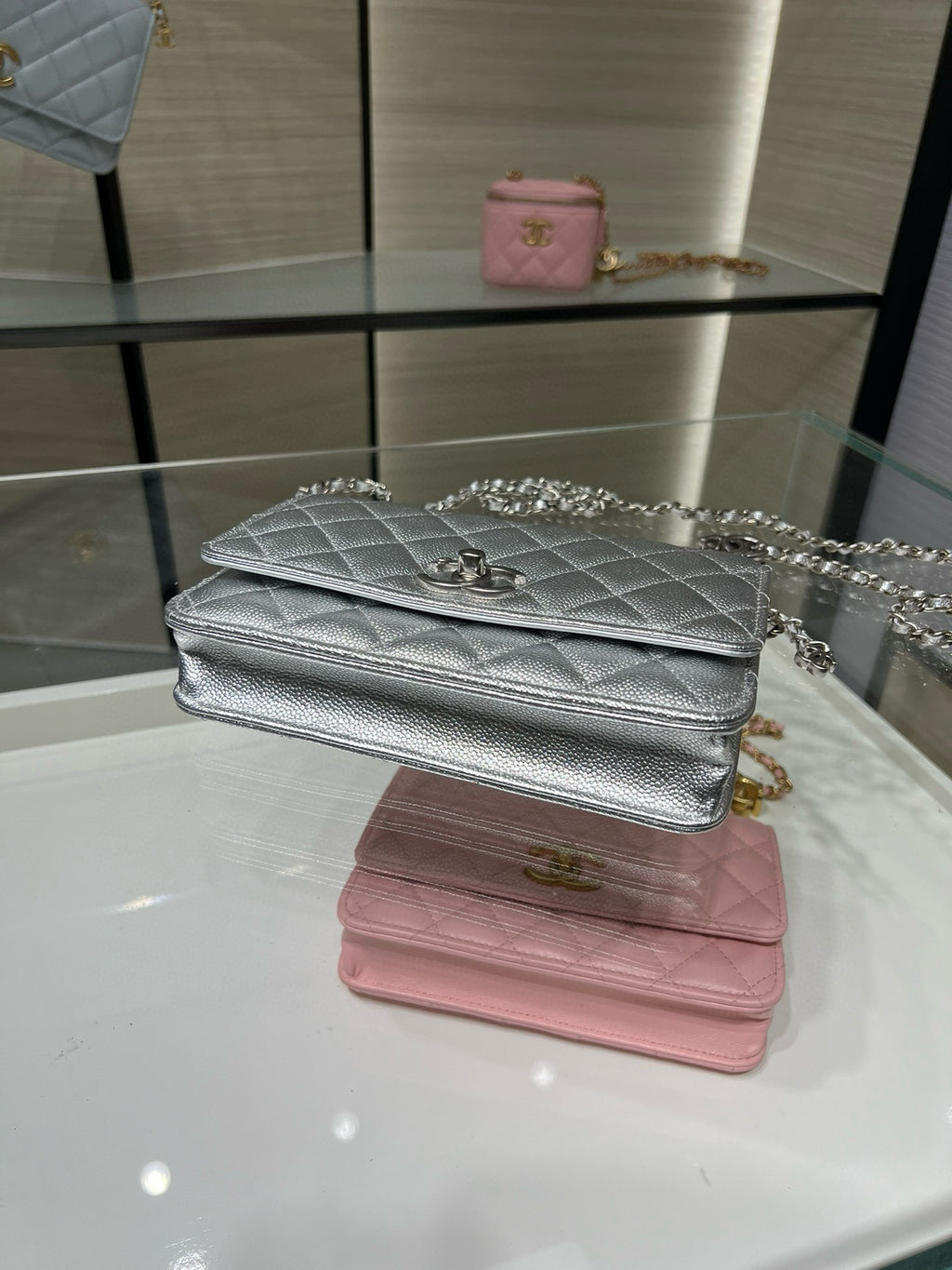Silver and pink Chanel flap bags with chain straps and quilted texture