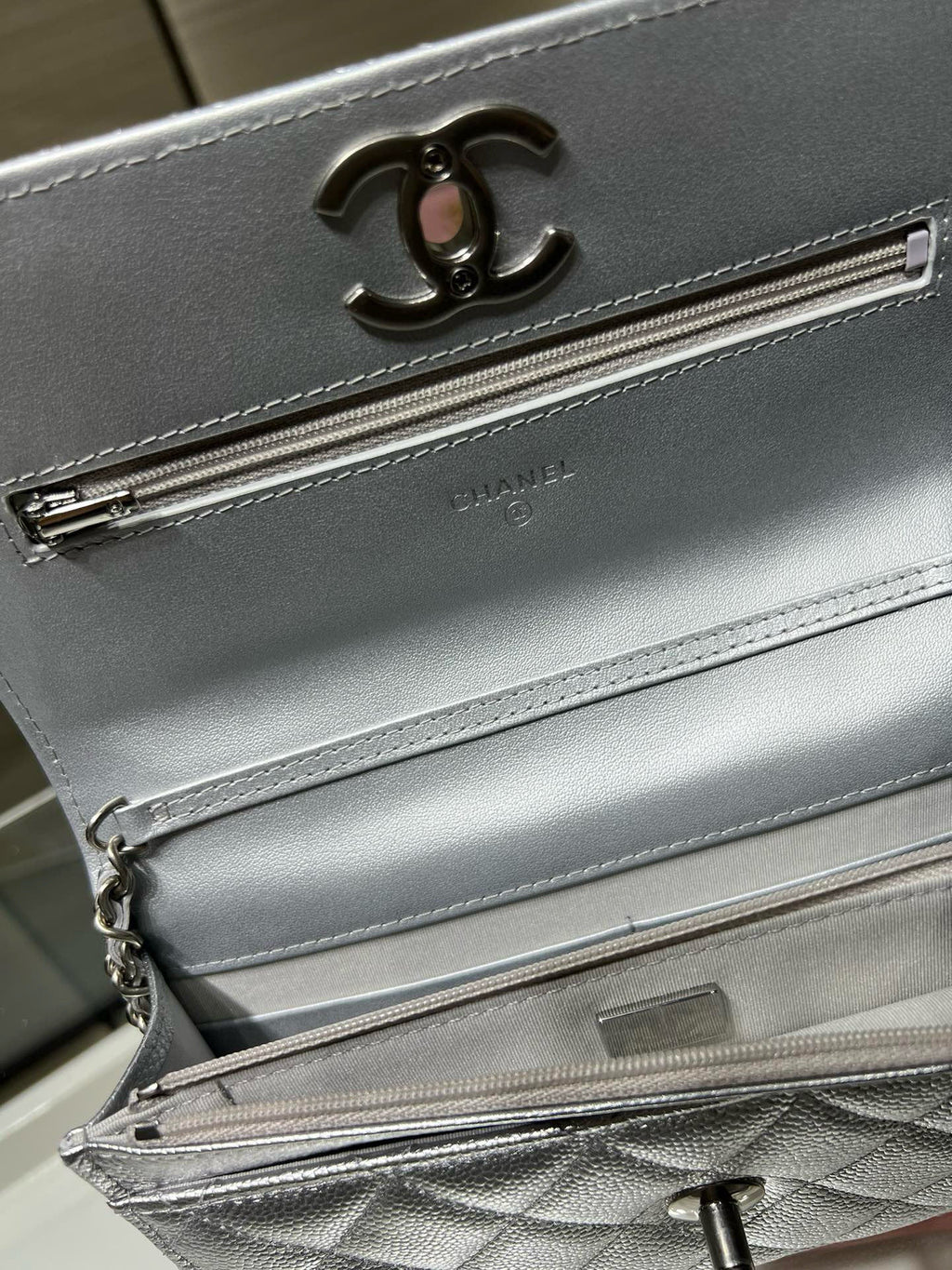 Silver Chanel bag front detail with CC logo and long zipper