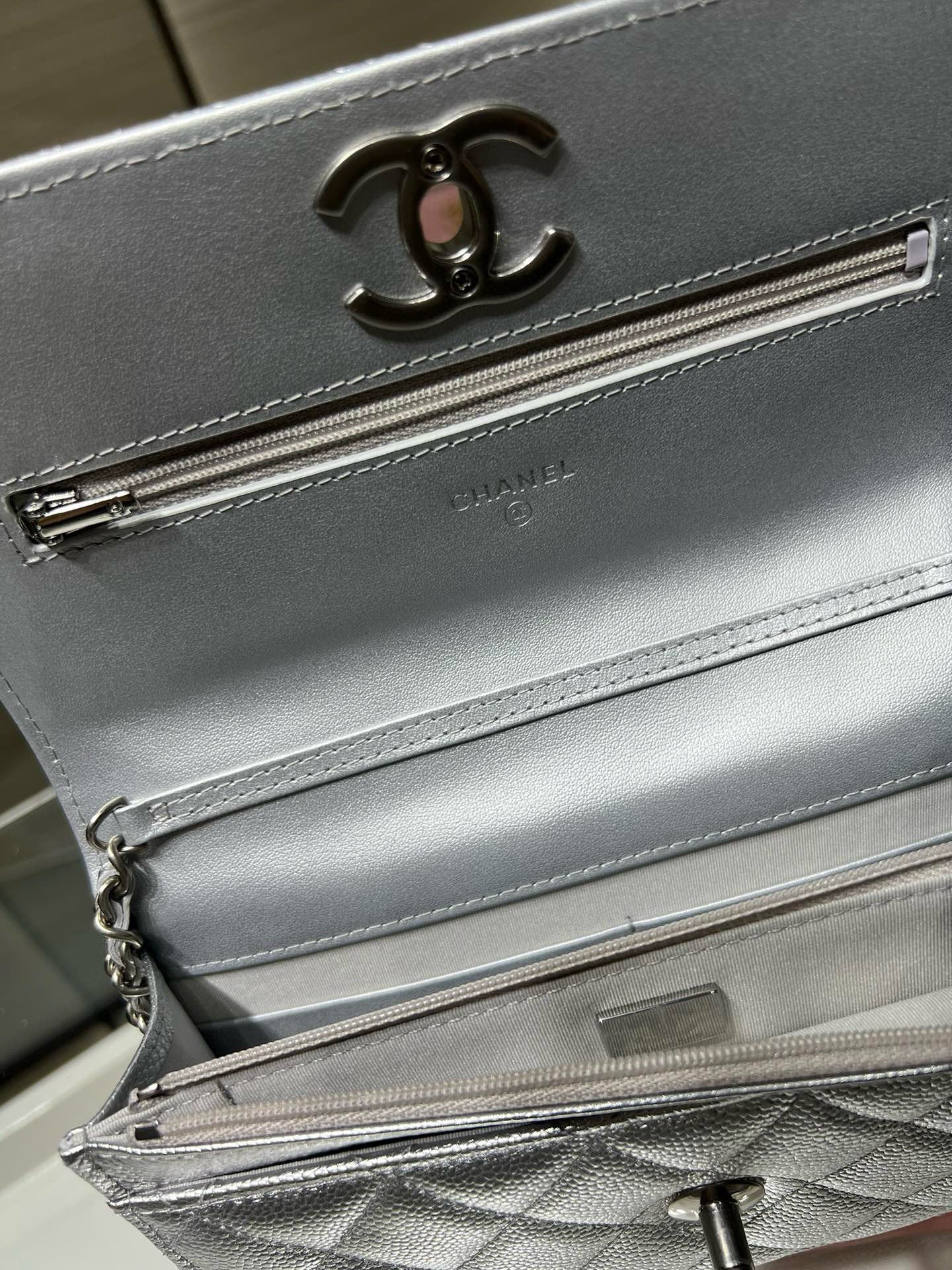 Silver Chanel bag front detail with CC logo and long zipper