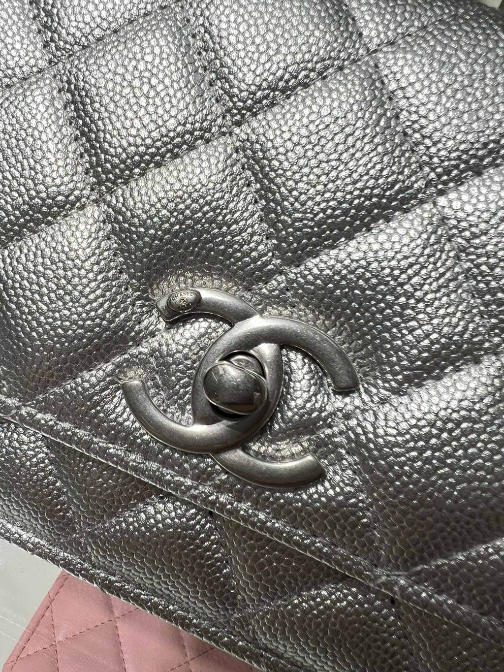 Silver Chanel bag detail with quilted texture and CC logo clasp