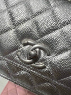 Silver Chanel bag detail with quilted texture and CC logo clasp