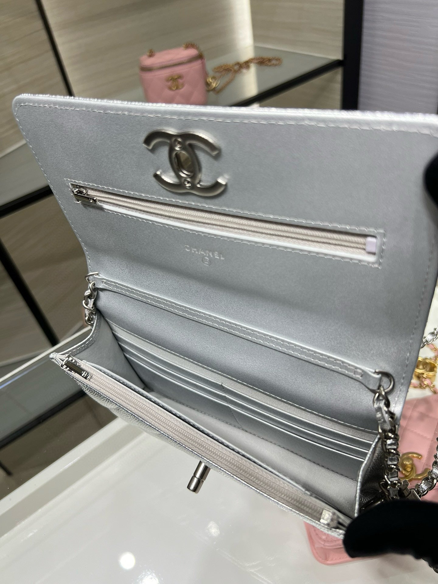 Silver Chanel flap wallet bag open to striped interior with chain strap