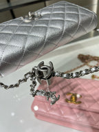 Silver Chanel quilted flap bag with metal chain strap and turn-lock hardware