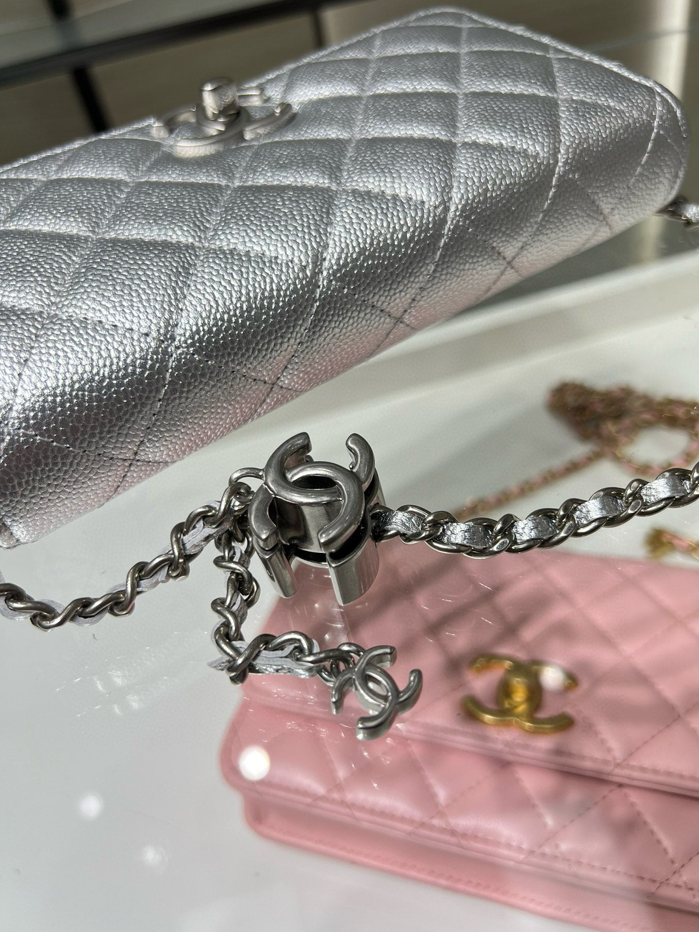 Silver Chanel quilted flap bag with metal chain strap and turn-lock hardware