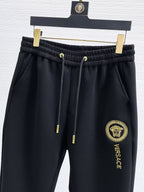 Black Versace sweatpants with elastic waistband, drawstring cords and thigh emblem