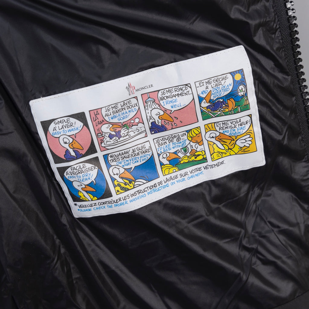 Moncler long puffer jacket interior comic-style logo patch on dark lining
