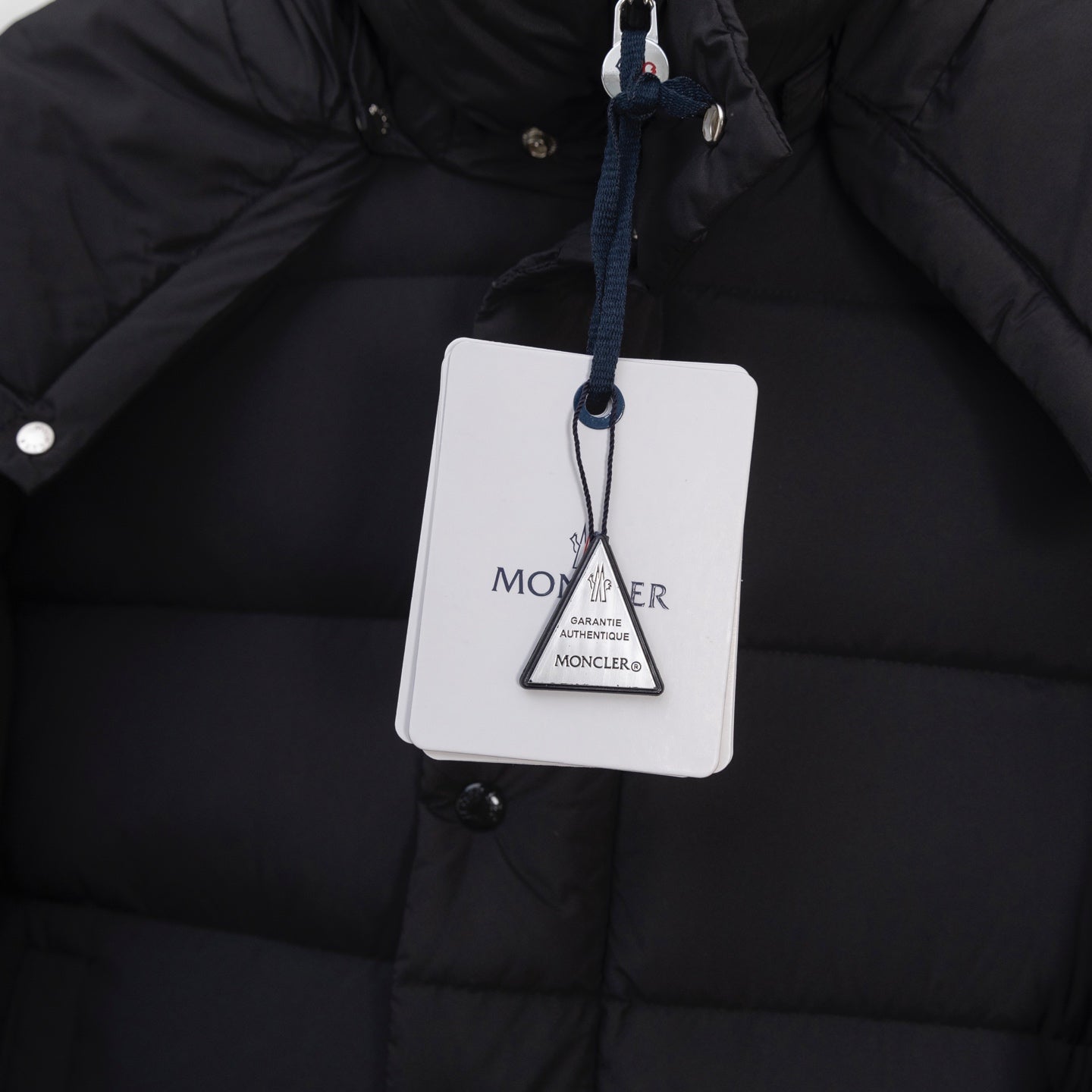 Moncler long puffer jacket with hanging size tag on front snap panel