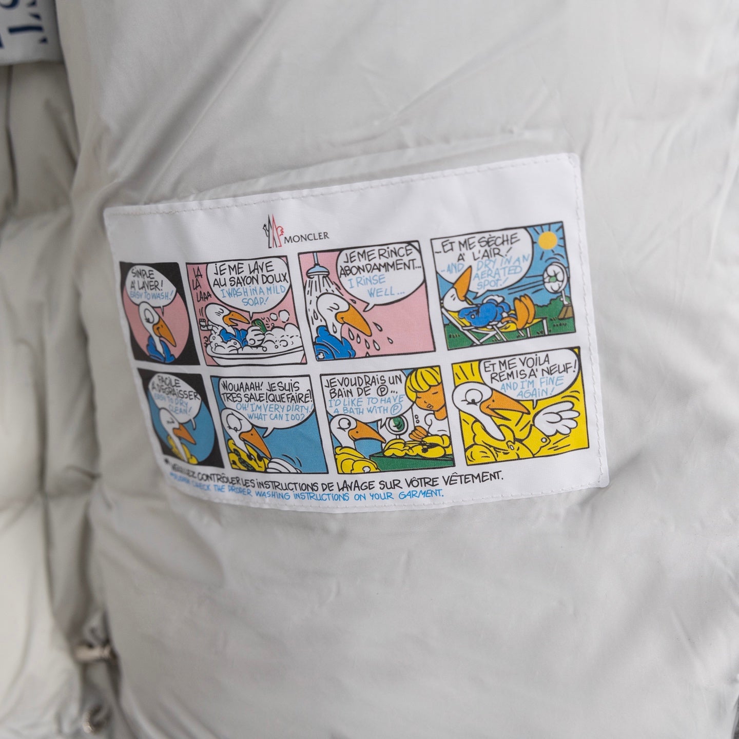 White puffer jacket inner care label with illustrated instructions