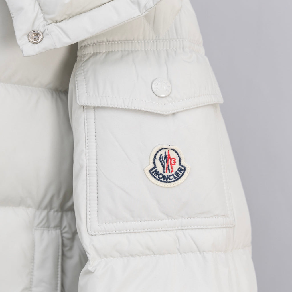 White puffer jacket front flap pocket with circular logo patch