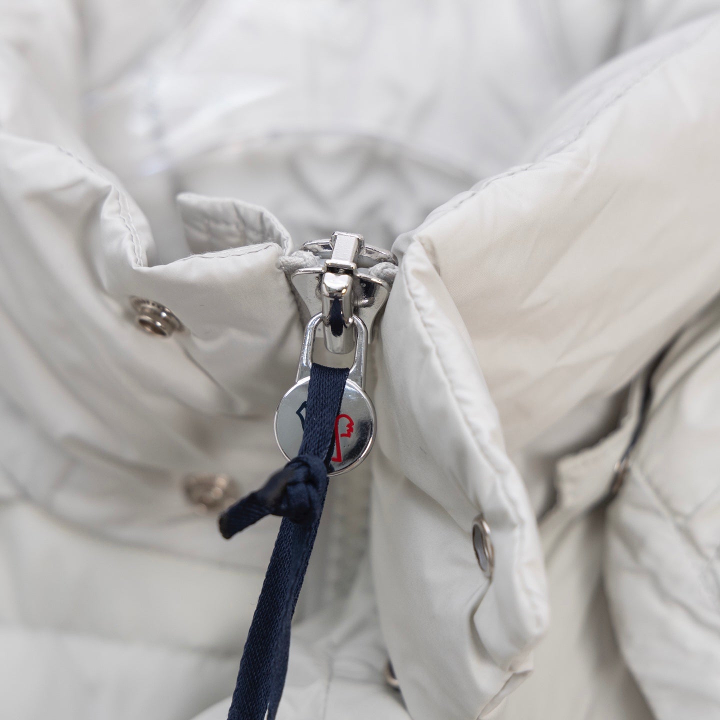 White puffer jacket with metal zipper and fabric pull tab